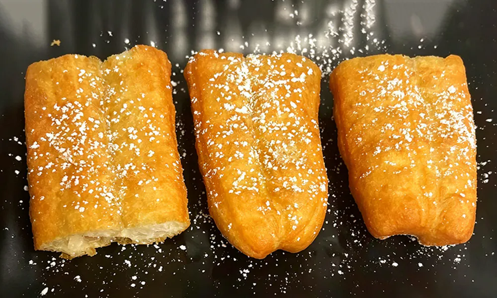 Golden fried dough sticks dusted with powdered sugar at Hongda Dough House, a Chinese Restaurant in North Plains